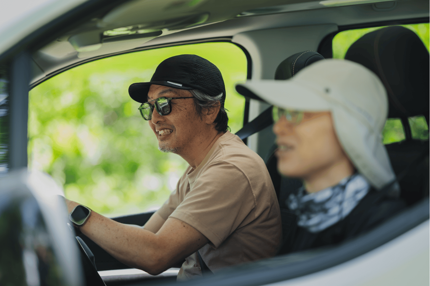 助手席の友人と笑顔で北へ向かう車内